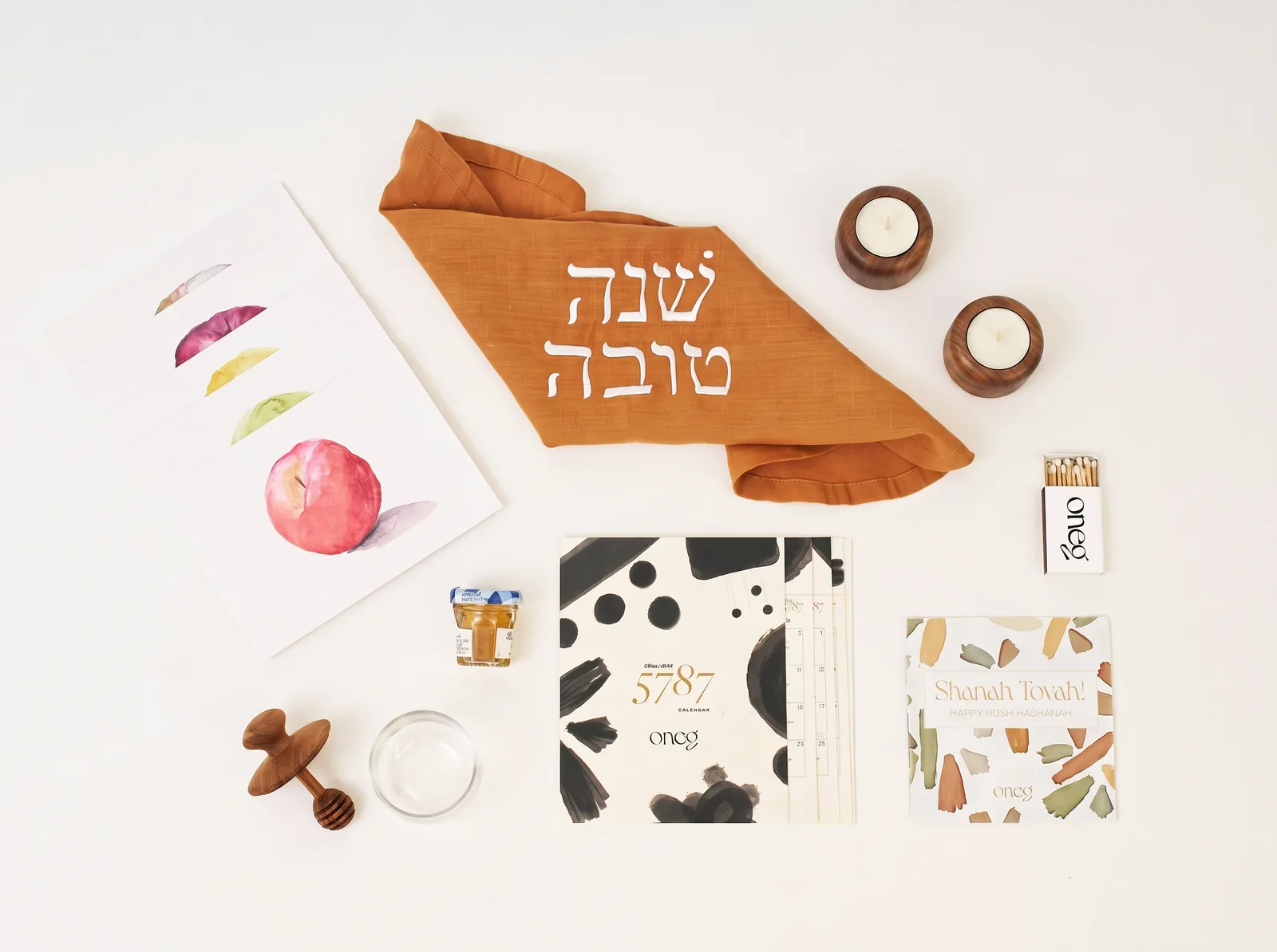 The Celebrate Box: round challah cover, honey jar and honey, greeting cards, the 5787 calendar, and tea lights.