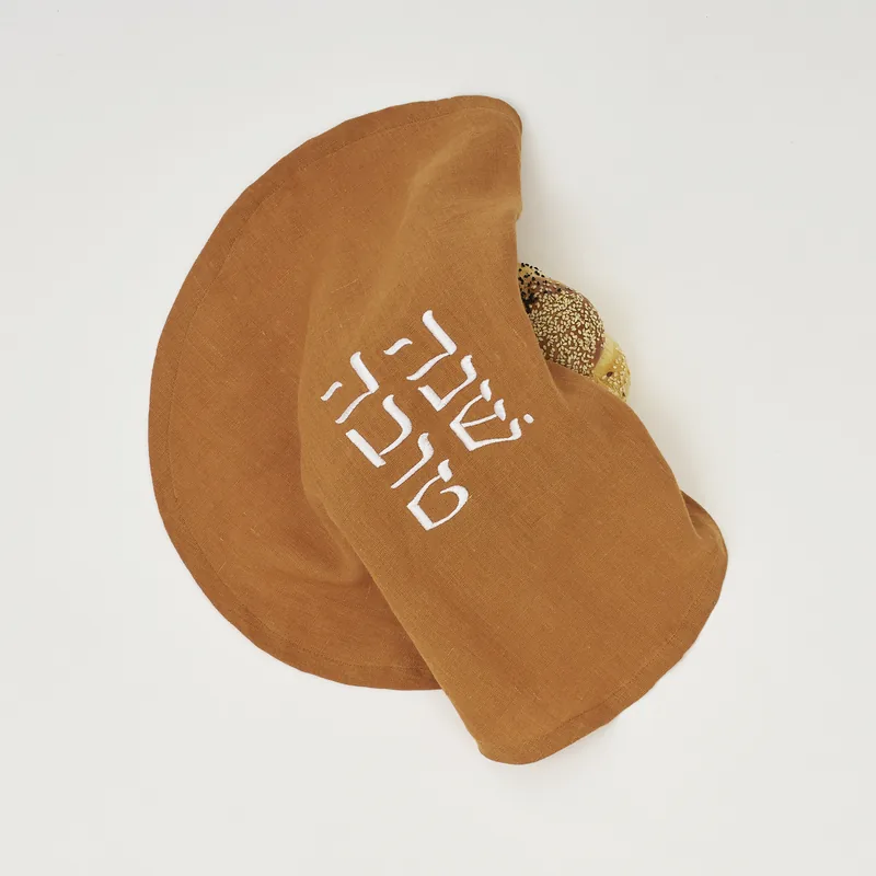 Studio photograph of the cinnamon round challah cover on a white backdrop.